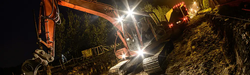 Heavy-duty equipment with lights on at a construction site