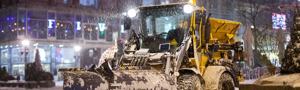 Snow plow plowing with lights on